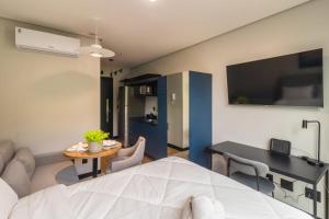 Zimmer mit einem Bett, einem Tisch und einem Esszimmer in der Unterkunft Edificio Village Lofts - Ao lado da Vila Germânica in Blumenau