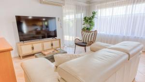 バッセルトンにあるJBs - Jetty Busselton Stayのソファと薄型テレビのあるリビングルーム