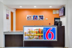 a television in a waiting room with an orange wall at Motel 6-White House, TN in White House