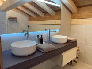 - une salle de bains avec deux lavabos sur un comptoir en bois dans l'établissement Chalet luxueux aux Gets, 4 chambres, sauna, parking privatif - FR-1-671-305, aux Gets