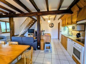 eine Küche und ein Wohnzimmer mit einer Couch und einem Tisch in der Unterkunft Chalet familial dans le Parc des Vosges, wifi et animaux acceptés - FR-1-589-840 in Le Ménil
