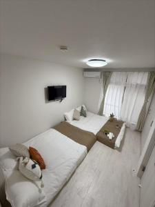 ein Schlafzimmer mit zwei Betten und einem Flachbildfernseher in der Unterkunft Taito-ku - House - Vacation STAY 20130 in Tokio