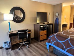 a hotel room with a bed and a desk with a computer at Super 8 by Wyndham Booneville in Booneville