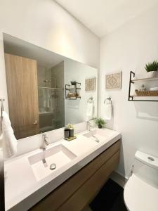 a white bathroom with two sinks and a toilet at Baia Krystal P4, 1A in Cartagena de Indias
