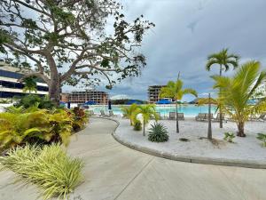 a walkway through a resort with trees and a beach at Baia Krystal P4, 1A in Cartagena de Indias