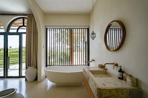 a bathroom with a large tub and a large window at Rumah Simba in Munggu