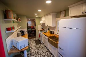チッカシェーにあるRalphie's House Chickasha - Fiber WIFI - 4 Bedroom!の白い冷蔵庫とテーブルのあるキッチン