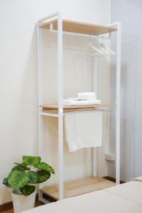 a white book shelf with a phone and a plant at Cozy KingsizeBed เจริญนคร in Ban Hua Phrong +11 photos