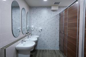 a bathroom with two sinks and two mirrors at Cozy KingsizeBed เจริญนคร in Ban Hua Phrong