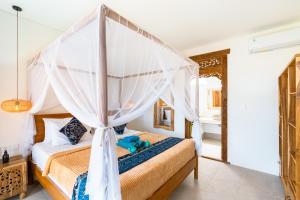 a bedroom with a canopy bed with a teddy bear on it at Villa Smarana 2bdrs with private pool in Balangan in Bingin Beach