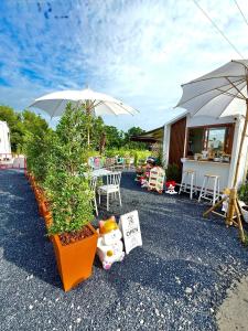a patio with a table and an umbrella and chairs at RT House Resort in Ban Phawon +16 photos