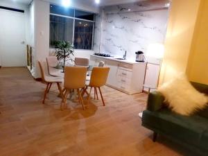 ein Wohnzimmer mit Tisch und Stühlen und eine Küche in der Unterkunft Departamento de Ensueño in Huaraz + 15 Fotos