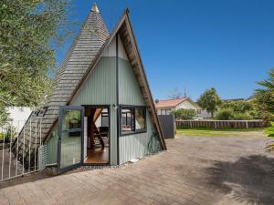a small green building with a pointed roof at The Sorting Hat - Pauanui Holiday Home in Pauanui