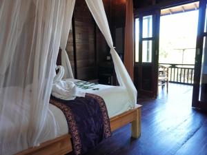 una camera da letto con un letto a baldacchino di Sunrise Cottage Lembongan a Nusa Lembongan