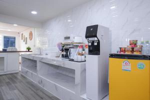 a kitchen with a white counter with a yellow refrigerator at Cozy KingsizeBed เจริญนคร in Ban Hua Phrong