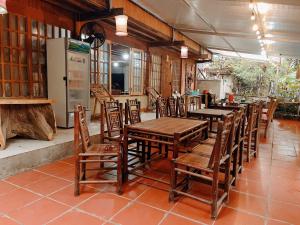 a restaurant with wooden tables and chairs and a refrigerator at Tả Mẩy Homestay in Lao Cai