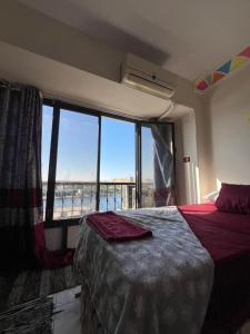 a bedroom with a bed and a large window at NubaNest GuestHouse in Aswan