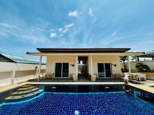 a villa with a swimming pool and a house at Aoonilay Resort Chaam-Huahin Zone B in Ban Bang Sai Yoi