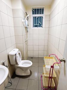 un baño con inodoro y lavabo en Pink DO HOMESTAY, en Kajang