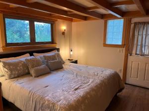 una camera da letto con un letto grande con due finestre di Still Point in the Woods ad Ashland