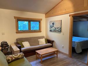 un soggiorno con un divano e un letto di Still Point in the Woods ad Ashland Altre 7 foto