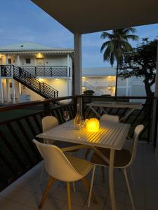 a table and chairs on a balcony at night at Morphée Lodge in Saint-François