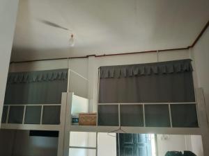 a room with a shelf with a curtain and a mirror at The Sun Backpackers Hostel in Nongkhiaw