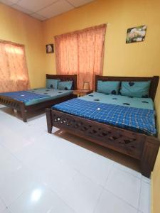 due letti seduti in una stanza conermottermottermottermott di Homestay Cenang Village Langkawi a Pantai Cenang
