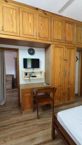 a bedroom with wooden cabinets and a desk with a television at Peyolis Place in Jāmb