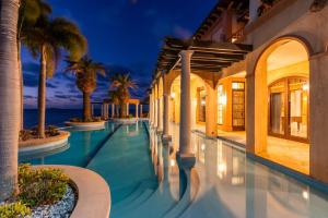 - une piscine dans une villa avec des palmiers dans l'établissement Ardea Whitsundays, à Airlie Beach