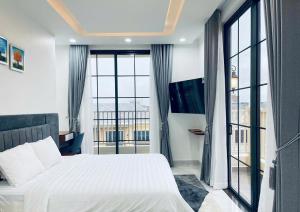 a bedroom with a bed and a large window at NovaWonderland Ho Tram Villa in Xuyên Mộc