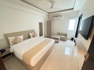een slaapkamer met een groot bed en een flatscreen-tv bij Hotel Crown Plaza in Prayagraj