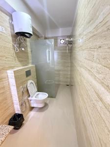 ein Badezimmer mit Toilette und Glasdusche in der Unterkunft Hotel Crown Plaza in Prayagraj