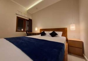 a bedroom with a large bed with a blue blanket at Mandala Living in Ketewel