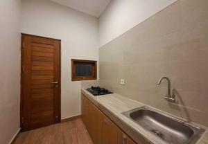 a kitchen with a sink and a wooden door at Mandala Living in Ketewel