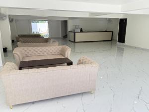 een kamer met vier banken en een tafel erin bij Hotel Crown Plaza in Prayagraj