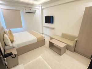 ein kleines Hotelzimmer mit einem Bett und einem TV in der Unterkunft Hotel Crown Plaza in Prayagraj + 33 Fotos