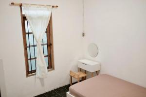 a white room with a bed and a window at Desa Huis Yogyakarta in Gandok +24 photos