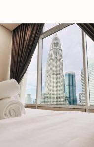 a bedroom with a view of a large building at Sky Suites KLCC Luxury Homestay in Kuala Lumpur