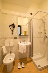 ein Bad mit einem Waschbecken, einem WC und einer Dusche in der Unterkunft Hotel Delizia in Mailand