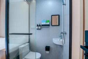 a bathroom with a shower and a toilet and a sink at 上海屿眠酒店 in Shanghai