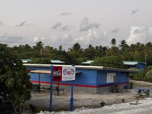 a blue building with a sign in front of it at Dream lodge II in Rangiroa