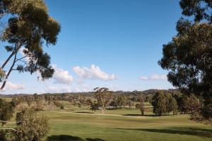 a view of a golf course with trees and a green at Yarra Valley Lodge in Wonga Park +77 photos