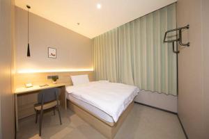 a small bedroom with a bed and a desk at hoco in Beijing