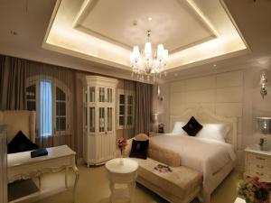 a bedroom with a large white bed and a chandelier at Xiamen Gulangyu Linshifu Gongguan Hotel in Gulang Yu