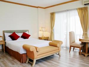 a bedroom with a bed and a chair and a piano at Romance Hotel Srinakarin in Bangkok +160 photos