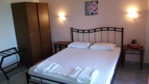 エディプソスにあるPark Hotel Edipsosのベッドルーム1室(白いシーツと枕のベッド1台付)