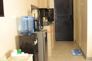 a kitchen with a refrigerator with a bottle of water on top at Reggyhomes in Nairobi