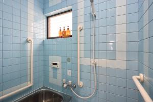 a blue tiled bathroom with a shower and a sink at 布袋屋 Hoteiya in Nara +40 photos