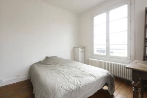 a white bedroom with a bed and a window at Chambres meublées chez l'habitant dans appartement proche gare sncf in Creil